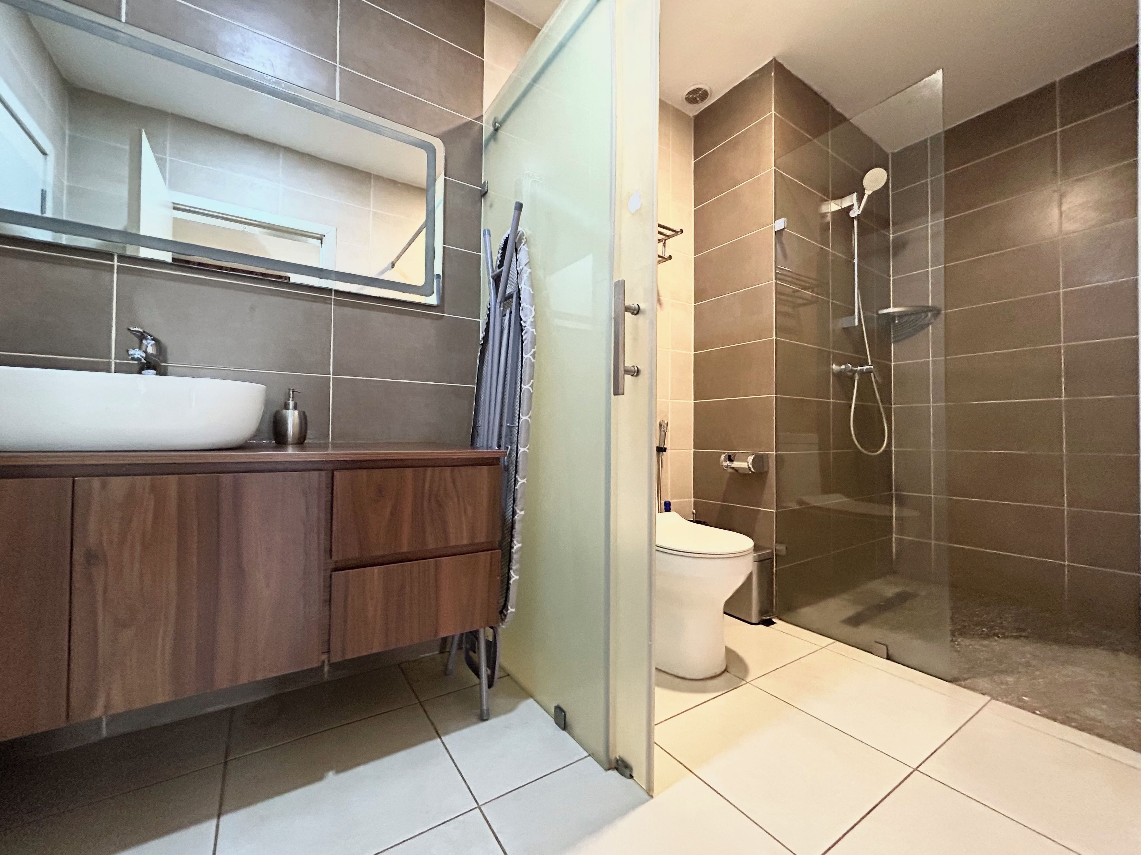 Un baño moderno con un lavamanos grande, espejo y zona de ducha.