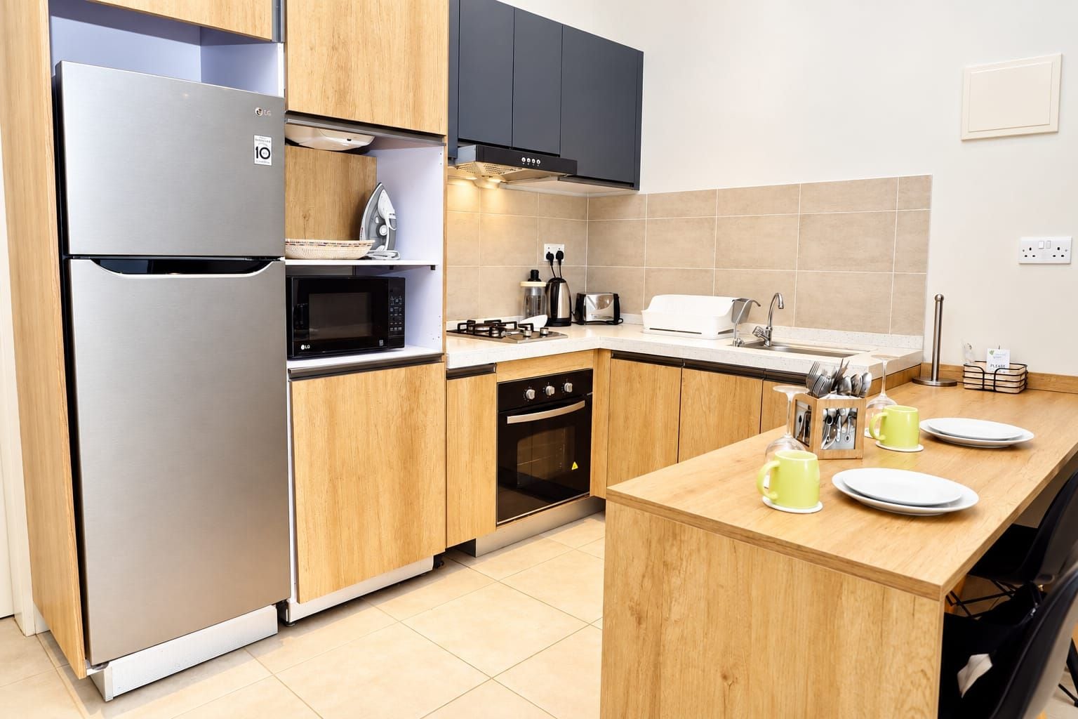 A modern kitchen with a stainless steel refrigerator, microwave, stove, and oven.