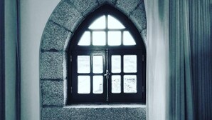 Ein Zimmer mit einem Fenster mit Rundbogen und einer weißen Wand.