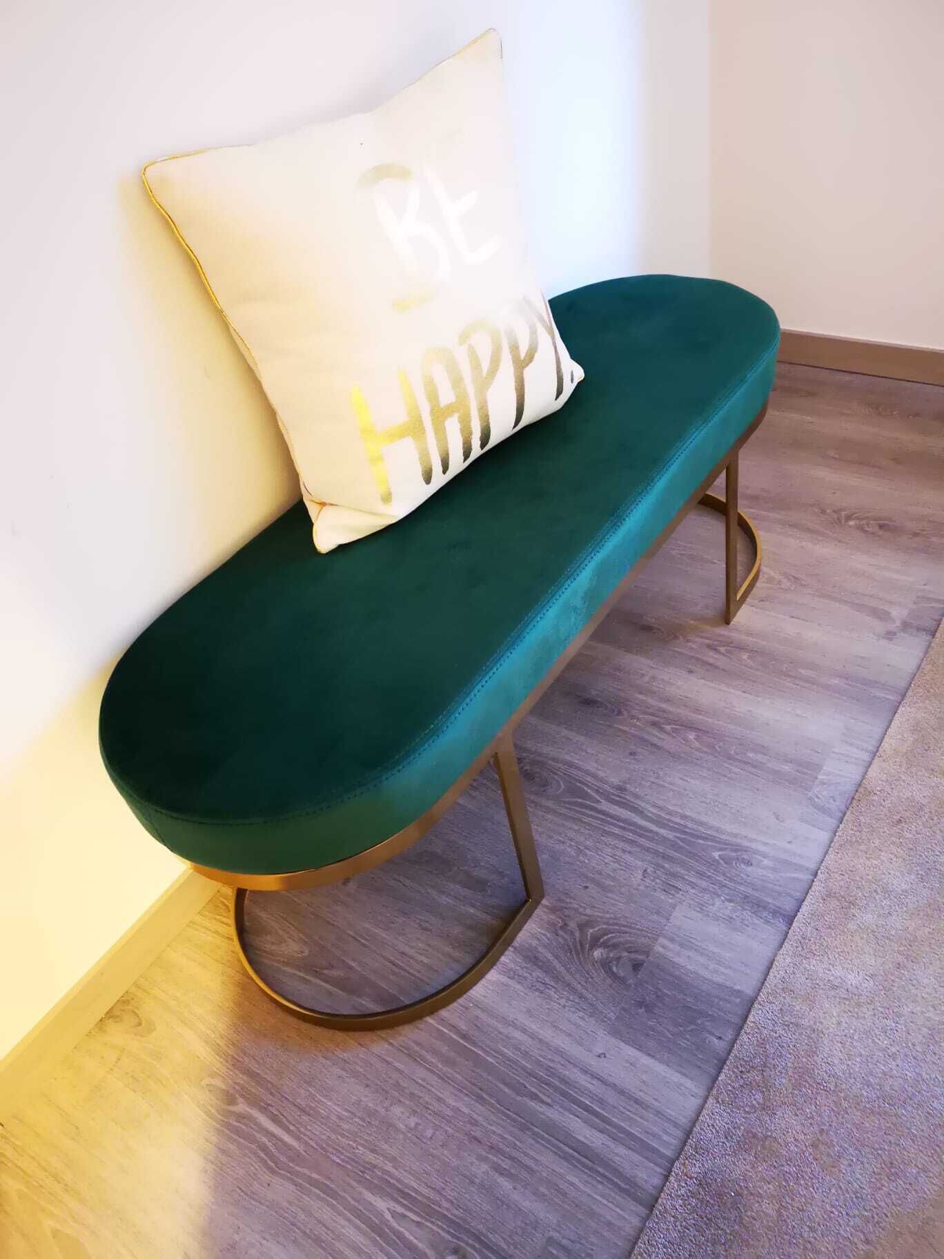 A teal bench with a gold-lettered pillow that says "BE HAPPY".