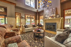 Relax in a spacious living area with a fireplace, plush sofa, and armchairs.