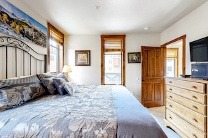 Cozy retreat with a large bed, dresser, and TV, offering a peaceful space to unwind.