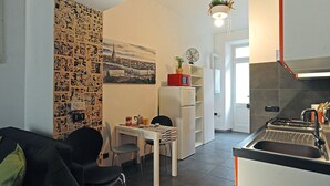 A compact kitchen with a dining area, a refrigerator, a microwave, and a sink. - La Casa di Mattoni by Wonderful Italy (Torino)