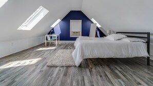 A bedroom with a sloped ceiling, a bed, a desk, and a chair. - 4BR/2BA Duplex Apt in Downtown Montclair w/Parking (Montclair)