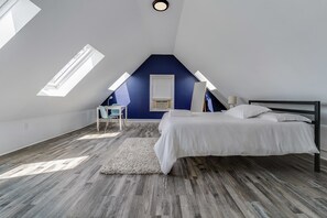 A bedroom with a sloped ceiling, a bed, a desk, and a chair. - 4BR/2BA Duplex Apt in Downtown Montclair w/Parking (Montclair)