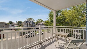 A covered outdoor area with a white railing, a table, and two chairs. - 4BR/2BA Duplex Apt in Downtown Montclair w/Parking (Montclair)