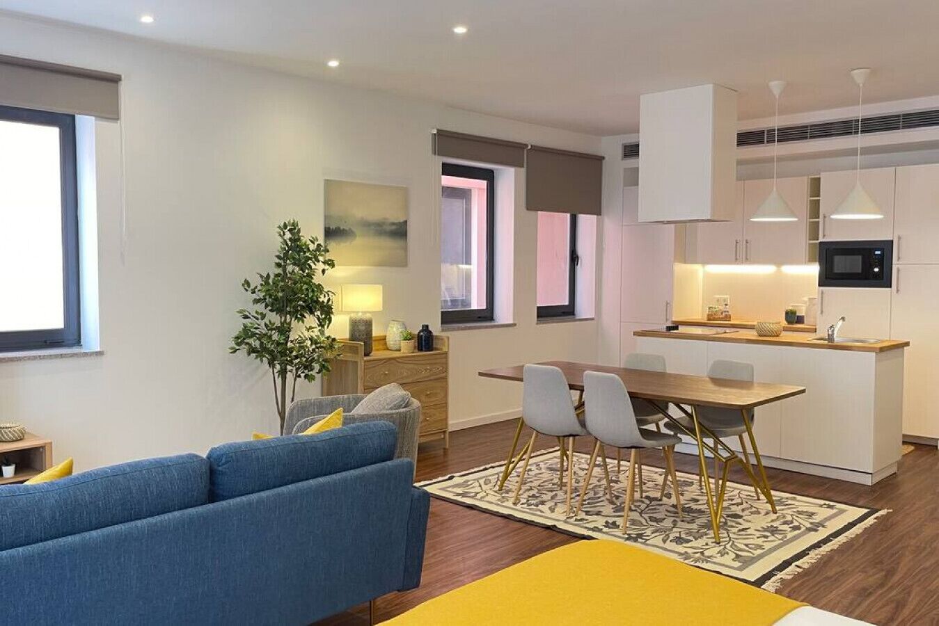 A modern apartment with a living room, dining area, and kitchen.