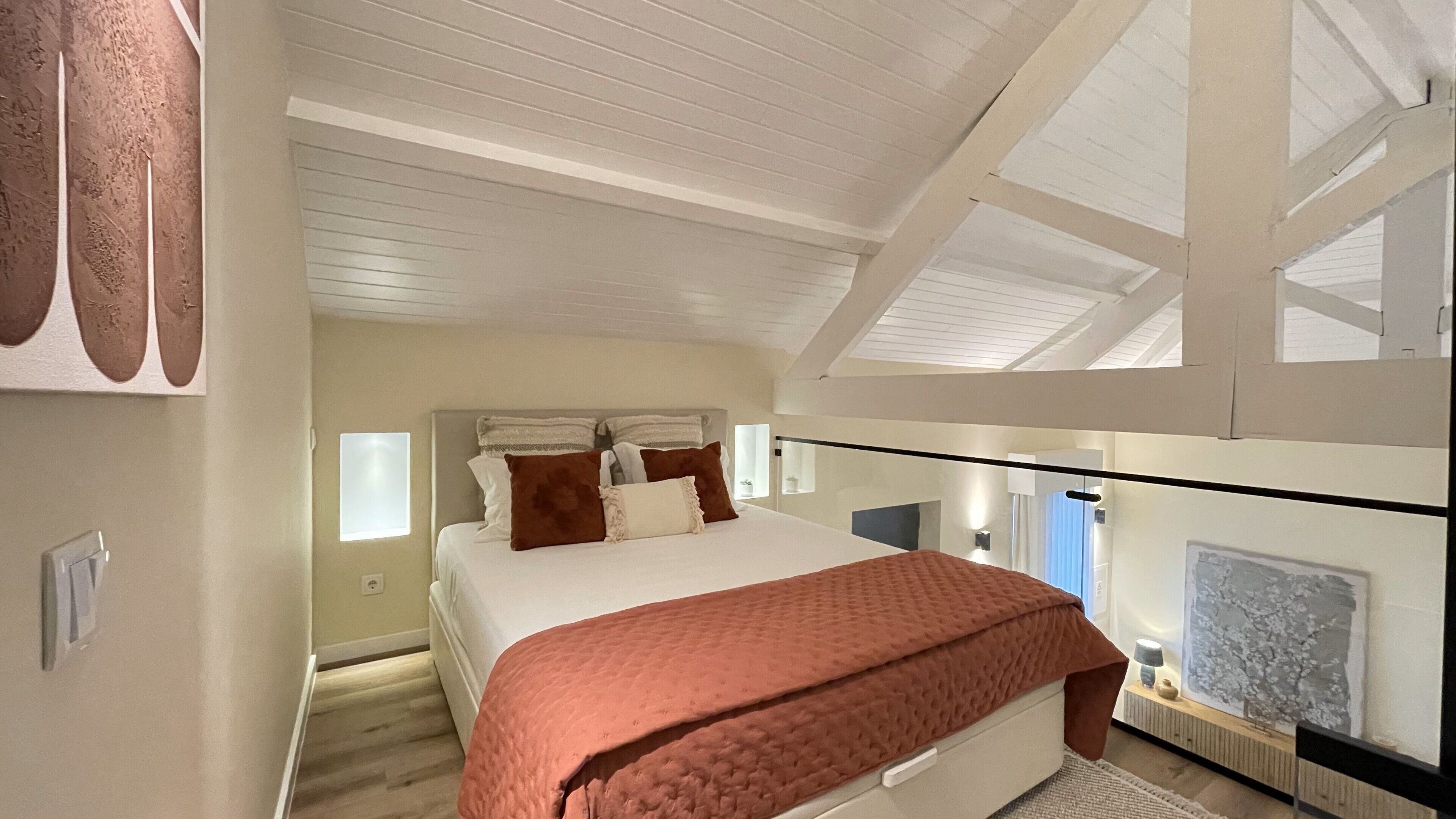 Una camera da letto con un letto, una finestra e un quadro appeso al muro.