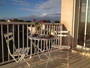 Enjoy a romantic evening on this balcony with a table for two, wine, and a beautiful view.