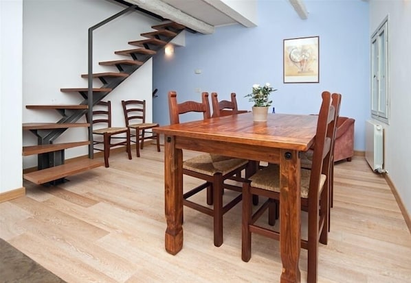 A dining area with a wooden table and chairs, a staircase, and a potted plant. - Lovely, Spacious Apartment in the Centre of Venice, (Venezia)