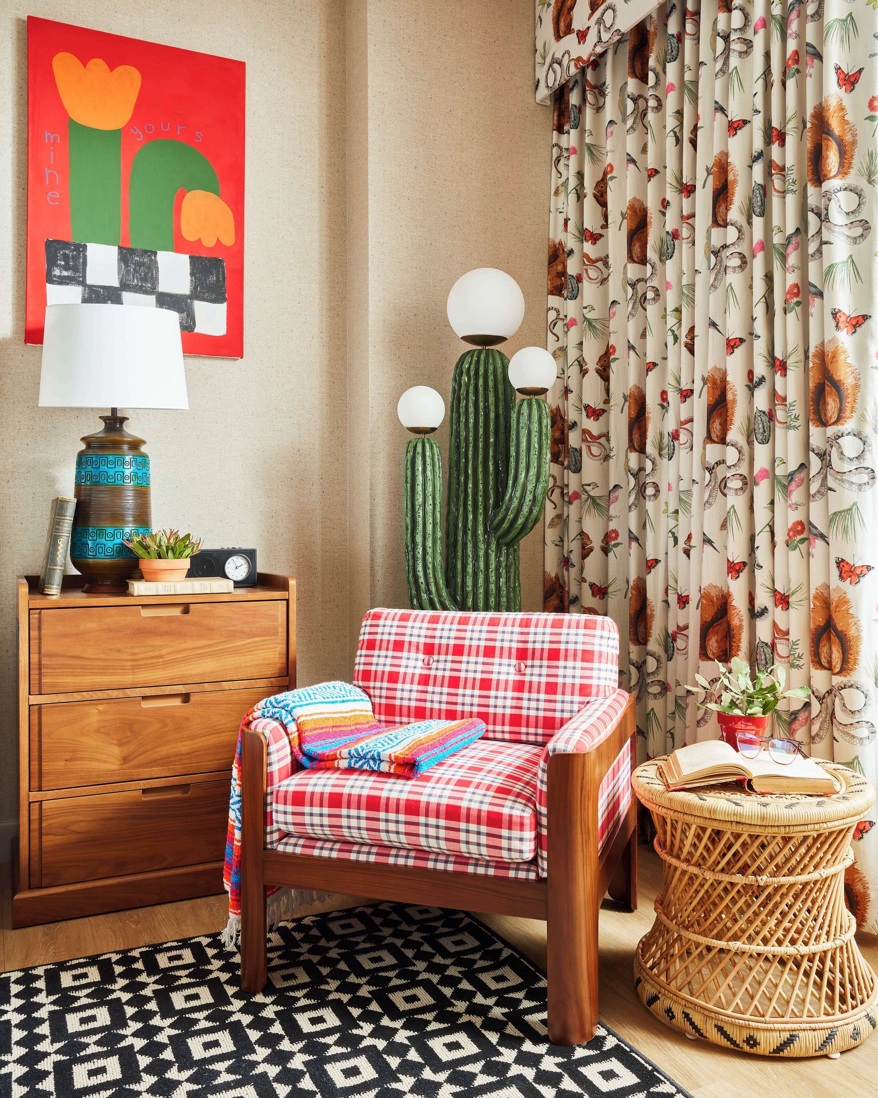 A cozy room with a plaid armchair, a wooden dresser, a cactus lamp, and a patterned rug.