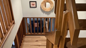 Gradi de fusta amb barana, un quadre amb una cranc i una decoració circular a la paret.
