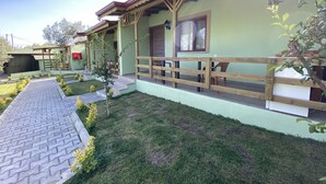 Ein Gebäude mit überdachter Veranda, einem Pflasterweg und einer Rasenfläche.