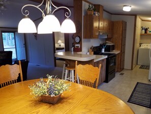 Una cocina con armarios de madera, una isla central y una mesa de comedor con sillas.