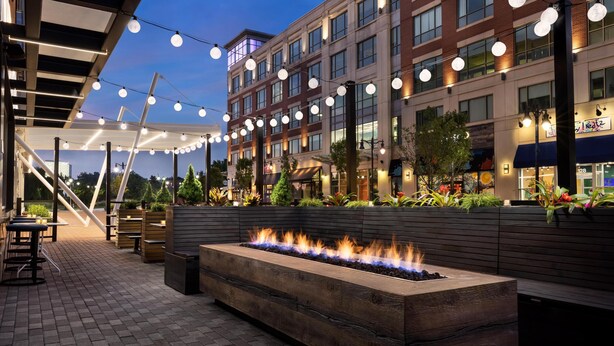 An outdoor patio with a fire feature, string lights, and a seating area. - Hyatt Place National Harbor (Oxon Hill)