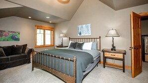 Un dormitorio con cama, mesita de noche, cómoda, ventana y puerta.