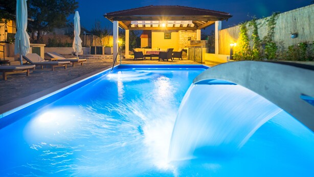 A swimming pool with a water slide, lounge chairs, and a covered seating area with tables and chairs. - Countryside House With Pool - Vila Šore (Dugobabe)