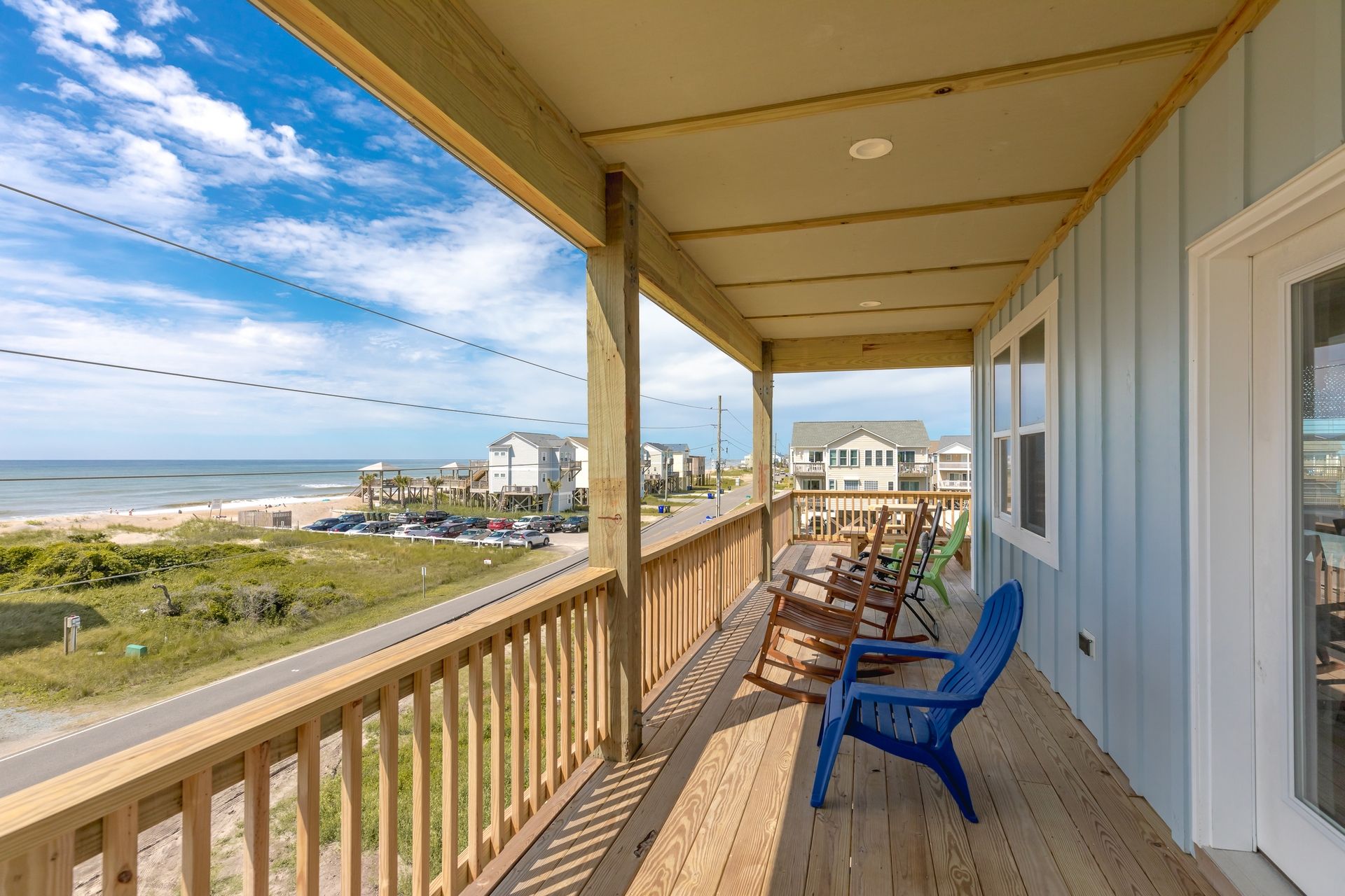 Une terrasse en bois offrant une vue sur la plage et l’océan.