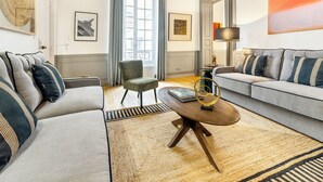 A living room with two sofas, a coffee table, a chair, and a large window.