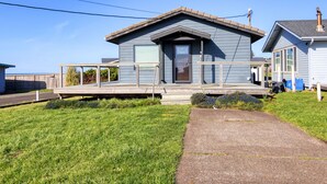 A two-story house with a covered porch, a garage, and a small deck.