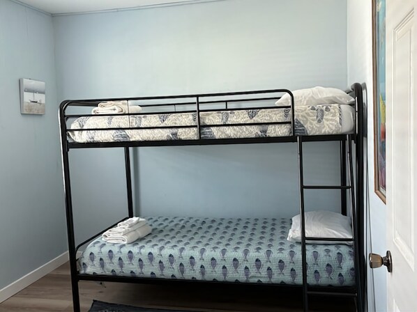 Un lit superposé avec un matelas à motifs dans une pièce aux murs bleu clair.