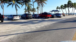 Een parkeerplaats met diverse auto's en een rode pick-up truck.