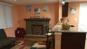 Uma sala de estar com lareira, sofá, mesa de centro e tapete.