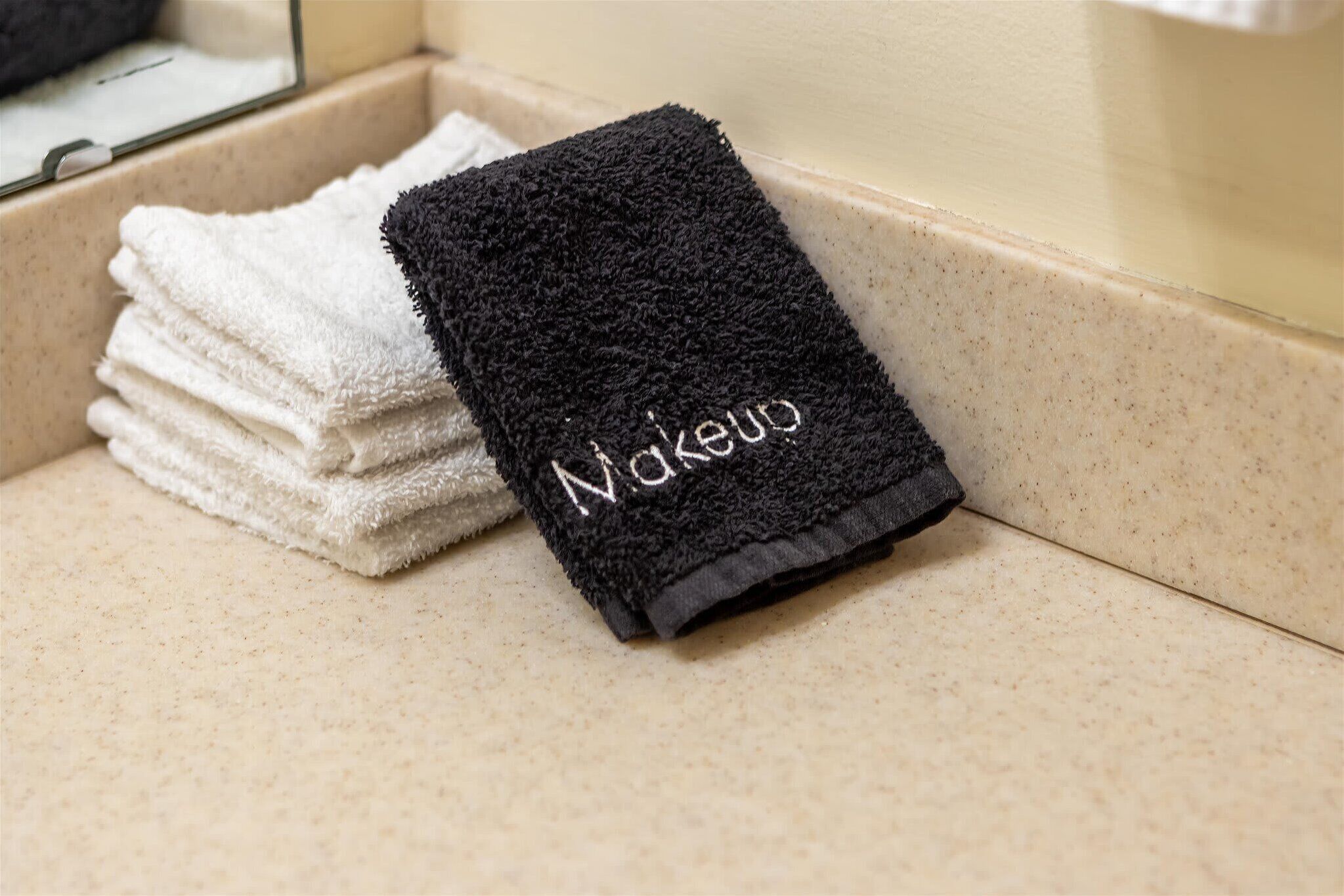 A stack of neatly folded towels with a black towel on top.