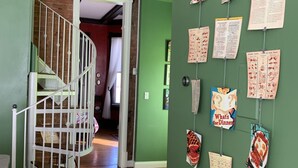 Eine Treppe mit weißer Geländer führt zu einem Zimmer mit grünen Wänden.
