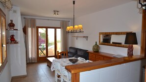 Una cocina con una mesa de comedor, sillas, un sofá y una encimera de madera.