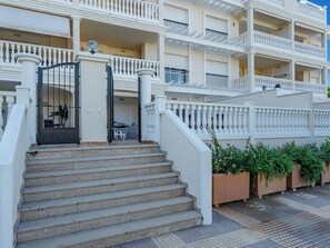 Un hôtel à plusieurs étages, doté d’une entrée imposante, d’un escalier menant à l’entrée et de plusieurs balcons.
