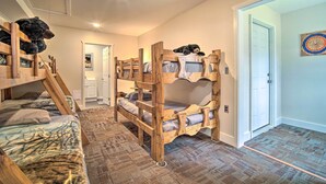 A bunk bed room with a ladder, a door, and a dartboard on the wall.