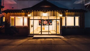 A building with a covered entrance and large windows. - Yamahana Onsen Tondenyu Ryokan (Sapporo)