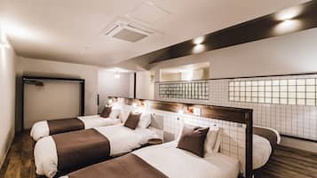 Quarto de hotel com duas camas, piso de madeira, parede azulejada e luminária no teto.