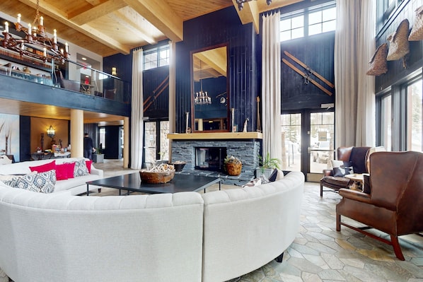 Relax in a stylishly designed space with a curved sofa, coffee table, and stone fireplace.
