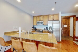 Enjoy cooking in this well-equipped kitchen with a central island, stainless steel sink, and microwave.