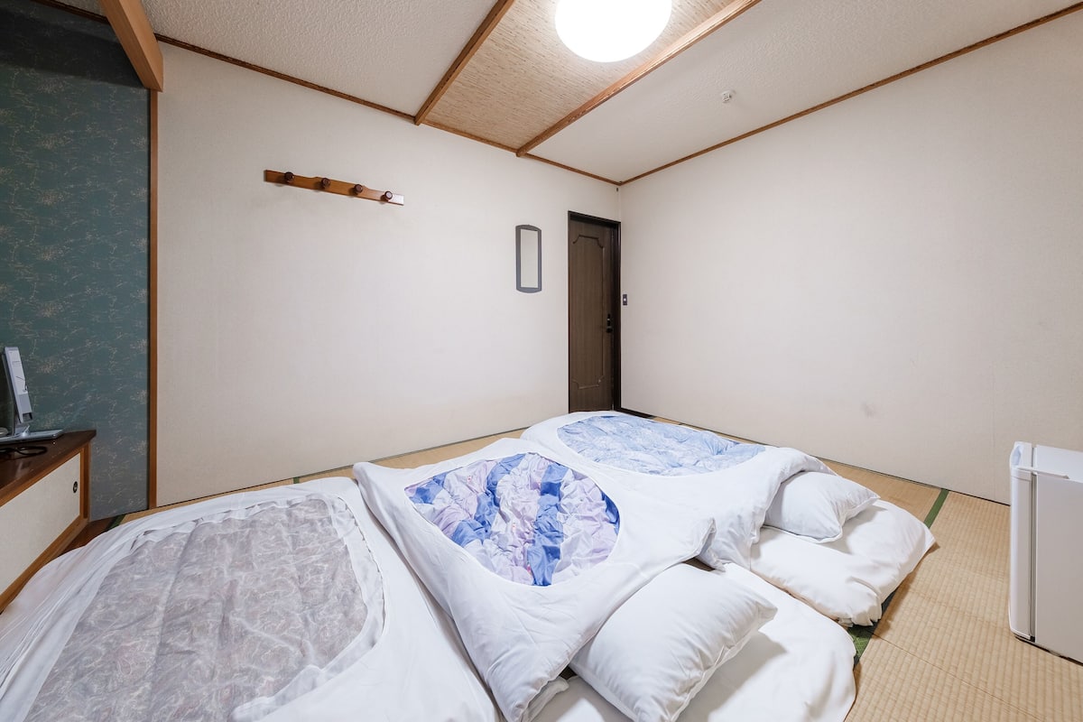 Une chambre avec deux lits, un bureau et une porte.