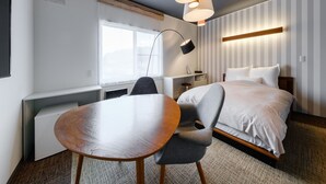 Une chambre d’hôtel moderne équipée d’un lit, d’un bureau, d’une chaise et d’une table à manger.