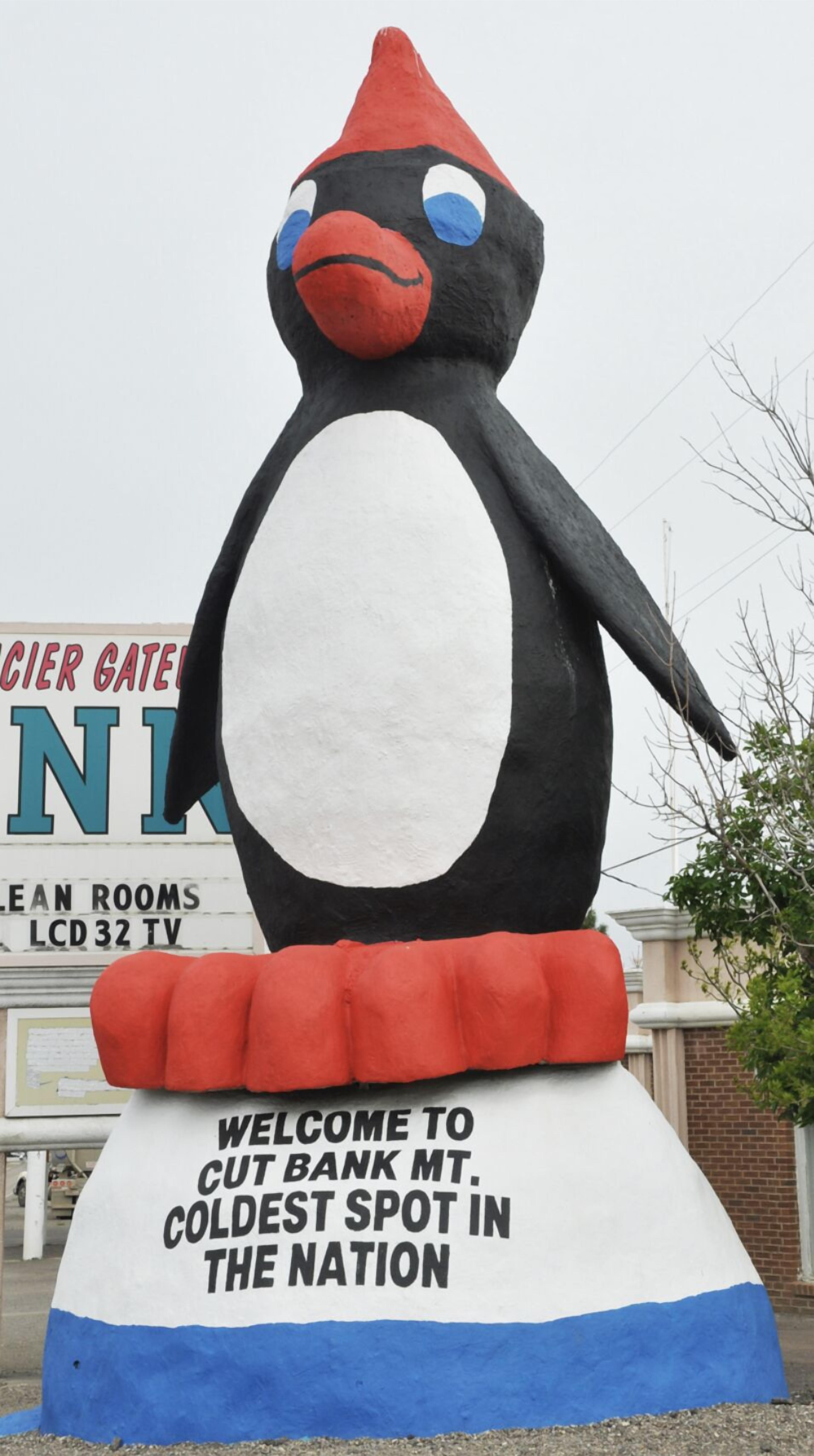 Een grote standbeeld van een pinguïn met een bord waarop staat: 'Welkom in Cut Bank, de koudste plek van het land'.