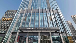 Un edificio alto y moderno con fachada de vidrio y una entrada destacada.