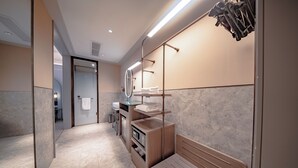 Un baño moderno con tocador, espejo, toallero y un banco.