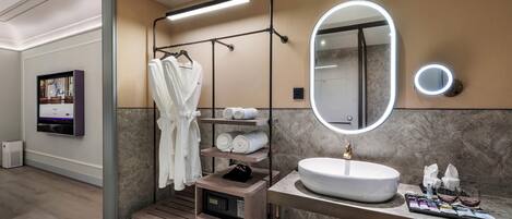 Un baño moderno con tocador, un espejo grande, un perchero para bata y un perchero para toallas.