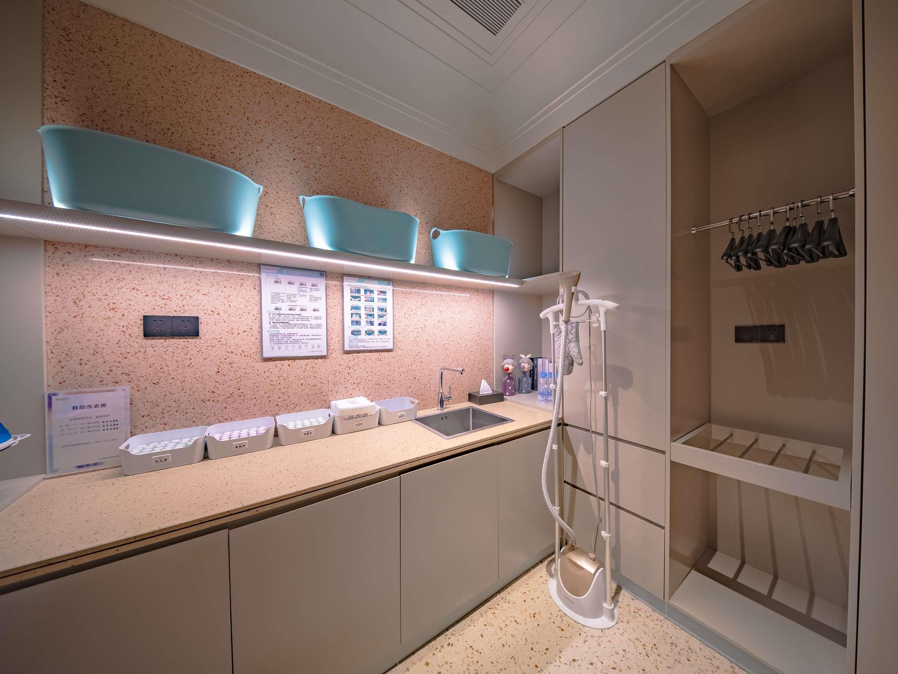 A modern bathroom with a countertop, sink, and shower area.