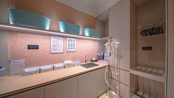 A modern bathroom with a countertop, sink, and shower area.