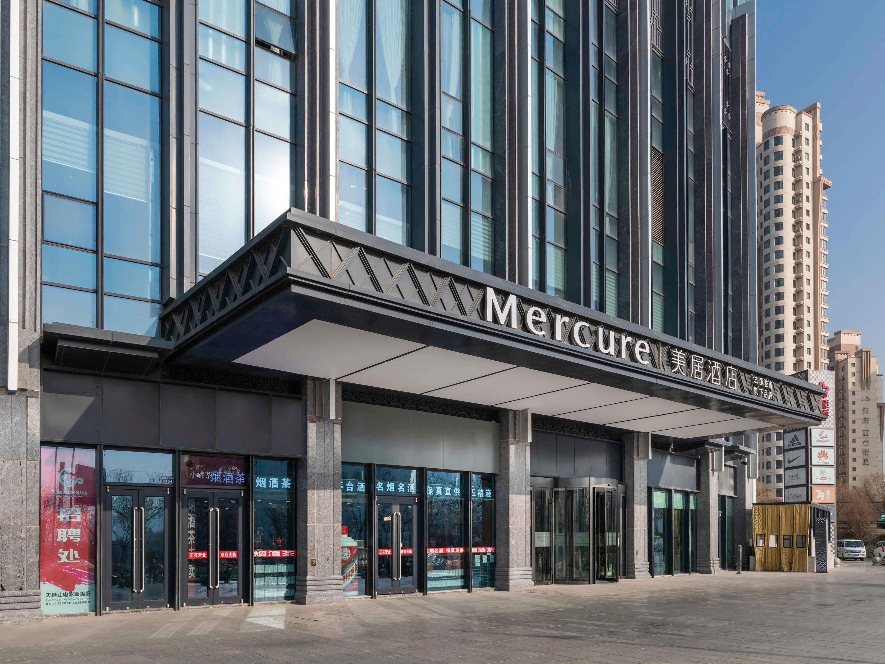 A modern building with a prominent sign reading 'Mercure Hotel'.