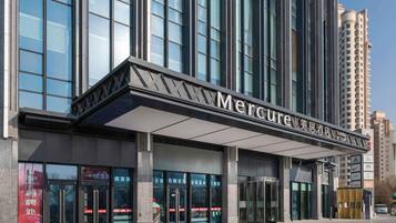 A modern building with a prominent sign reading 'Mercure Hotel'.