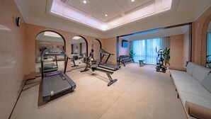 Un gimnasio con cintas de correr, elípticas y pesas sueltas.