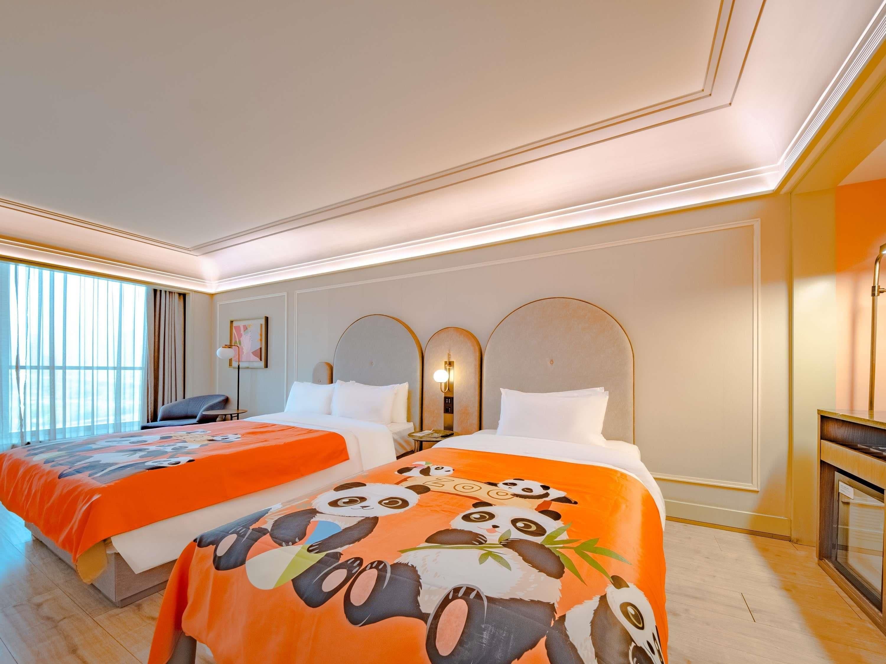 Une chambre d’hôtel avec deux lits, un bureau et une grande fenêtre.