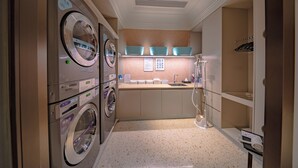 Un cuarto de lavandería con dos lavadoras, un lavamanos y un espejo.