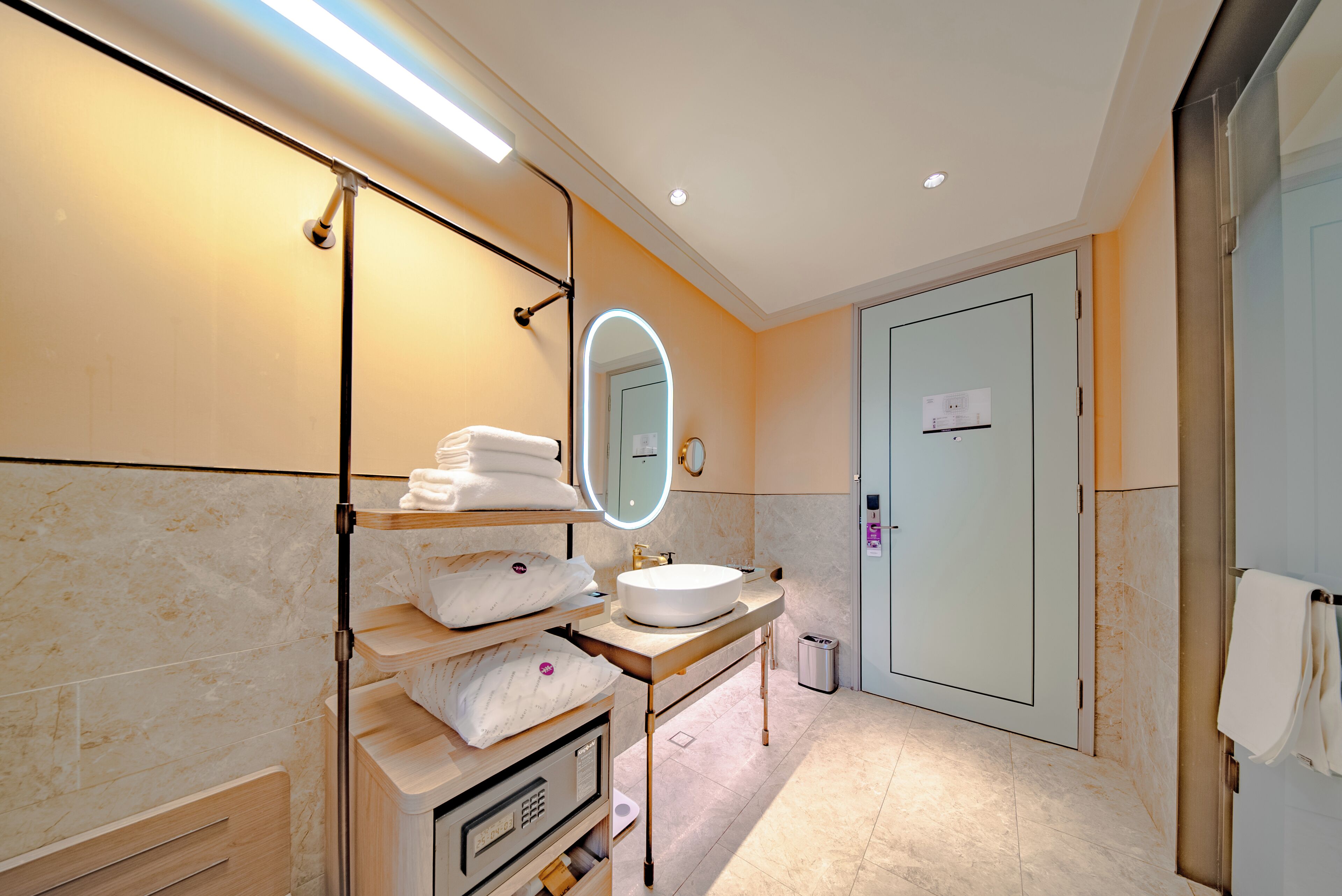 A modern bathroom with a vanity, sink, mirror, and towel rack.
